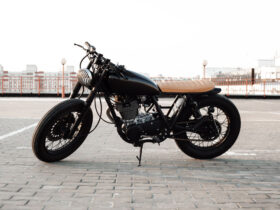 Motorbike. Road and city with open sky on background. Vintage custom motorcycle